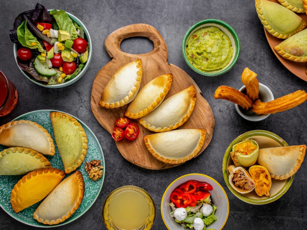 Empanadas gebakken op een bord voor een echt latin feestje. Argentijnse streetfood cultuur komt hierin echt naar voren. De Guacamole is een mooie dip saus om naar de Empanadas te serveren